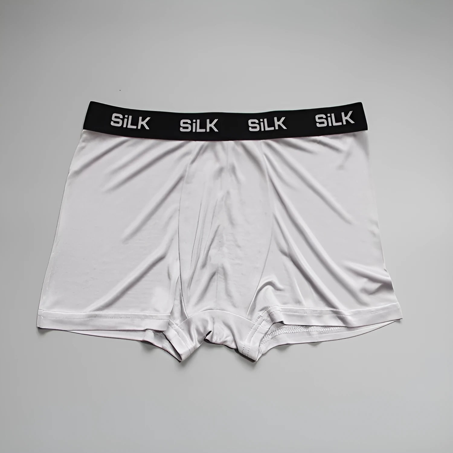 Man wearing loose fit navy blue silk shorts with a mid waist design.