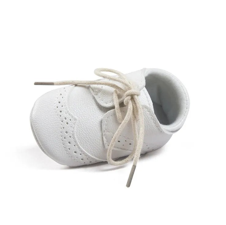 Vintage baby shoes with soft soles in light brown colour showing synthetic leather upper