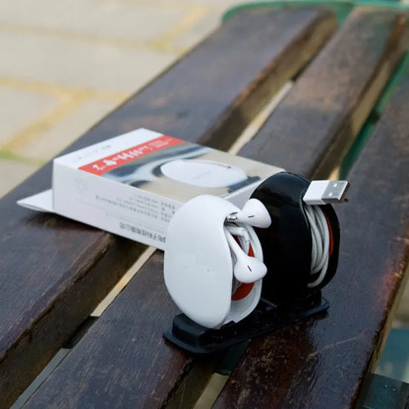 Automatic earphone retractor winder in black with extended cable showing push-type mechanism