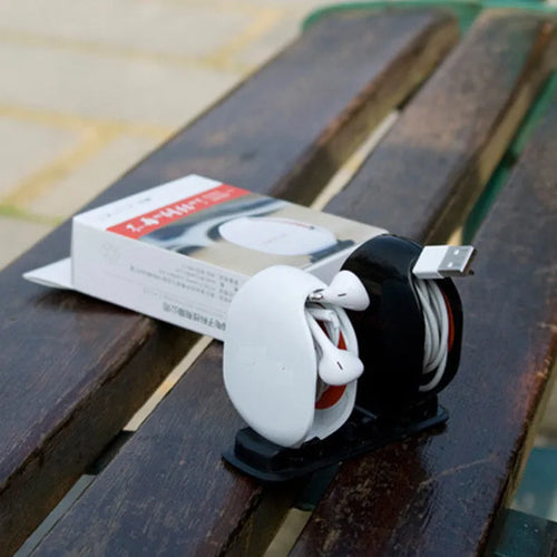 Automatic earphone retractor winder in black with extended cable showing push-type mechanism