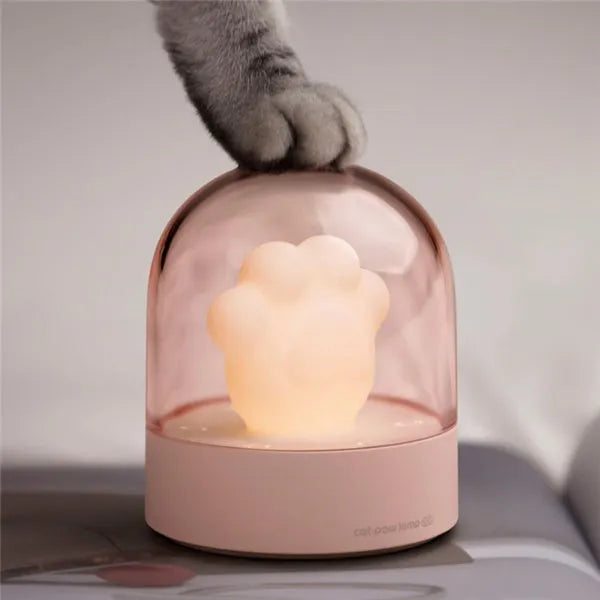 Grey cat paw shaped USB rechargeable night light and music box with soft glowing light.