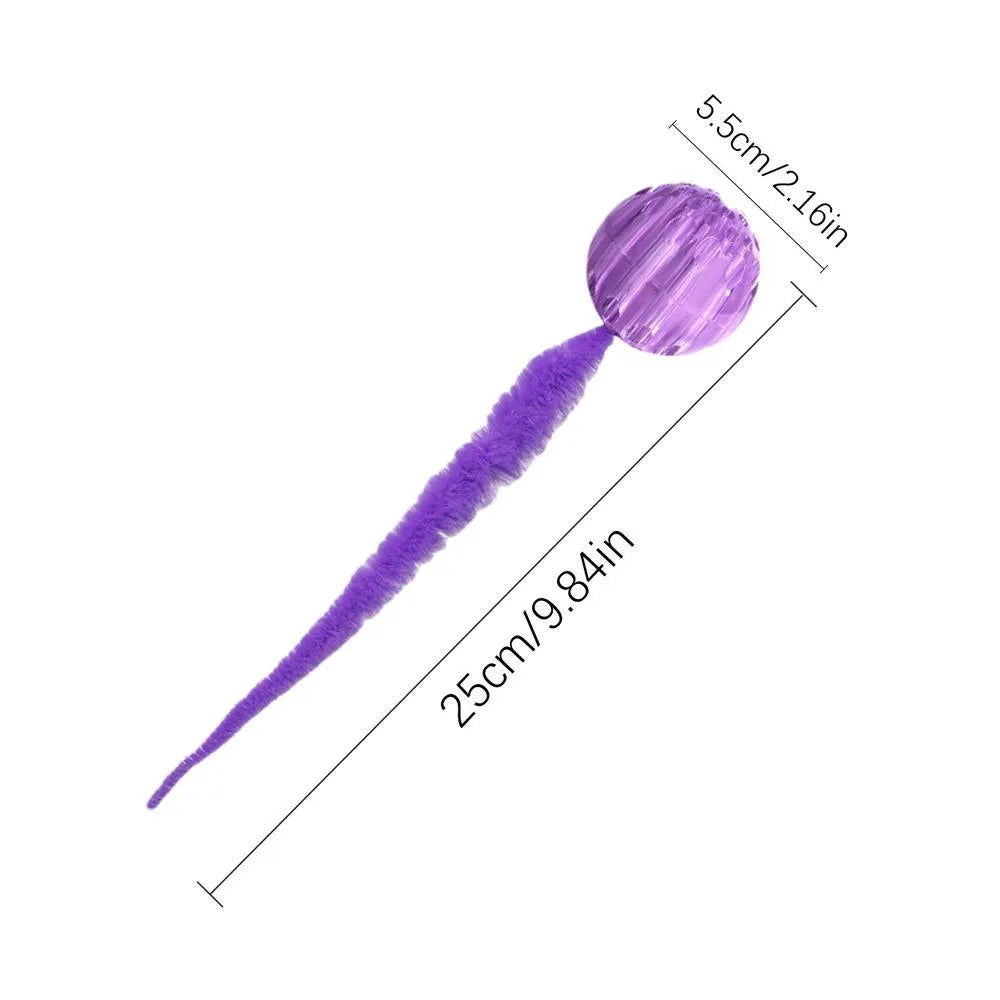Green interactive cat toy featuring a bouncy ball with a long plush tail on a wooden floor.
