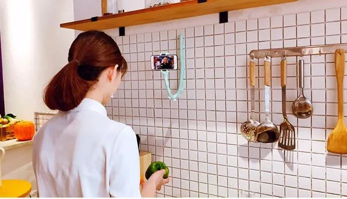 Flexible worm design mobile phone holder with suction cup mounted on desktop showing 360-degree rotation