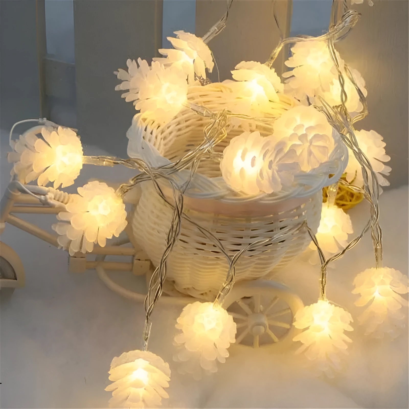 Warm white LED pine cone light string with plastic shells, powered by two AA batteries.