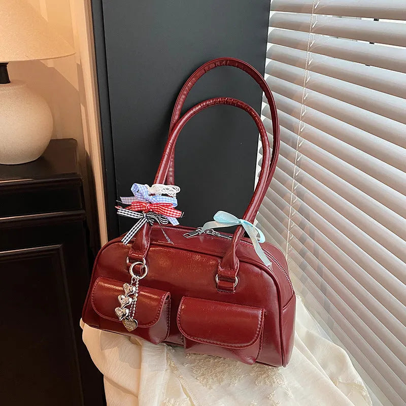 Retro pillow-shaped leather women's handbag with one shoulder underarm design in black with ribbon pendant