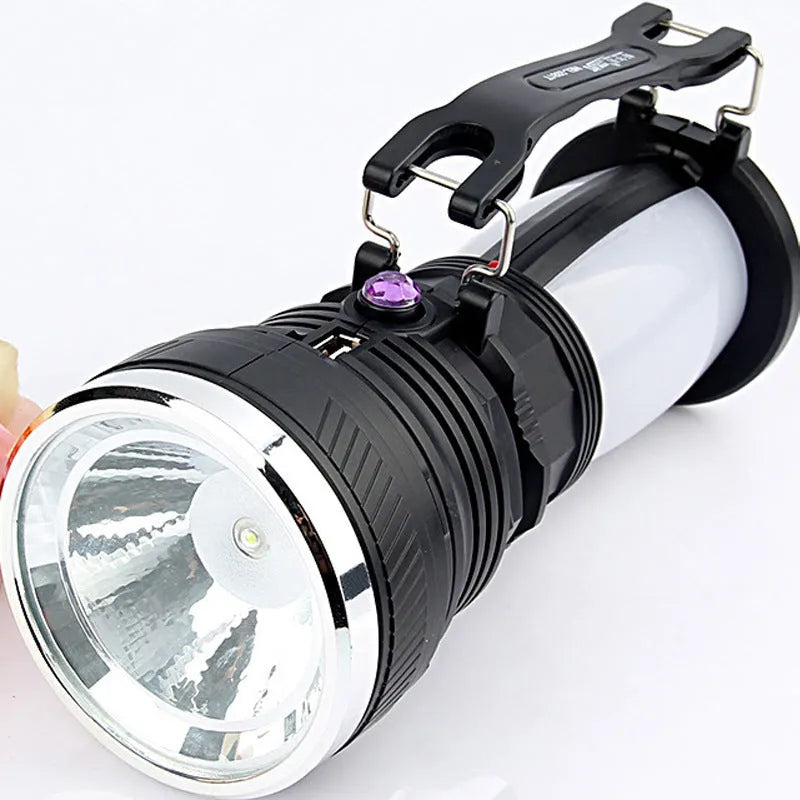 Black solar-powered LED flashlight with USB charging port shown on a textured background.