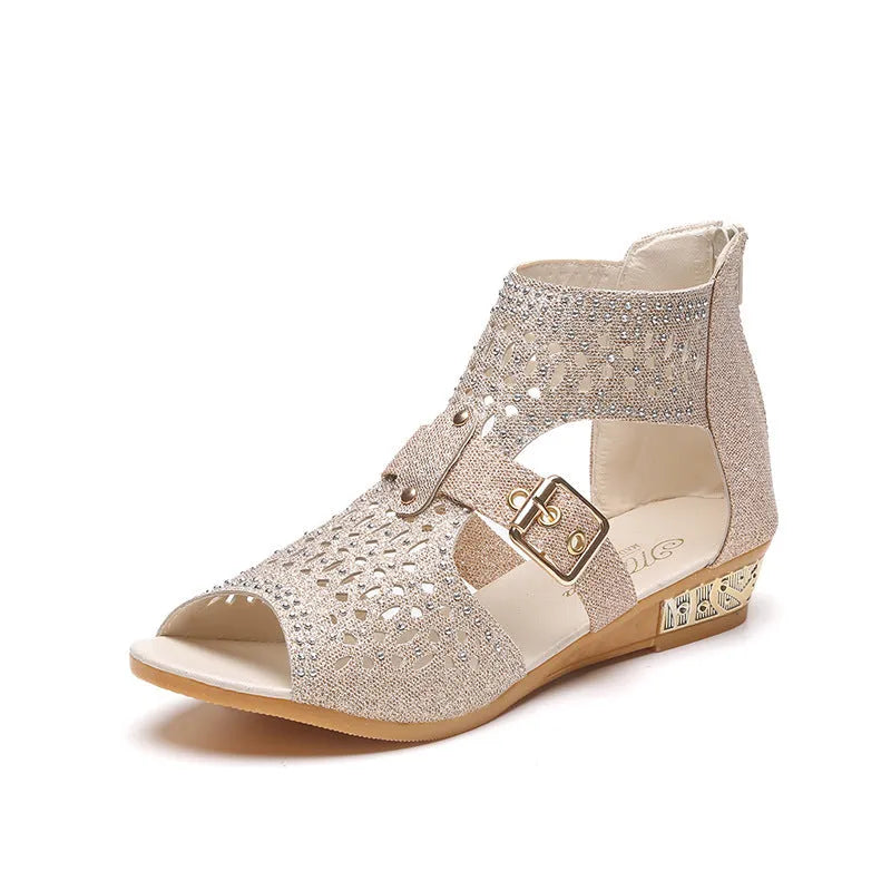 Women's beige flat sandals with back zipper and low wedge heel on a white background.