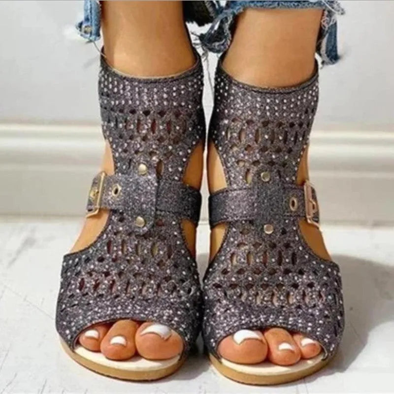 Women's beige flat sandals with back zipper and low wedge heel on a white background.