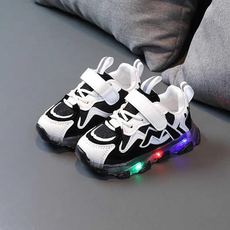 Kids' black sports sneakers with mesh panels and a Velcro strap closure on a rubber sole.