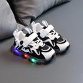 Kids' black sports sneakers with mesh panels and a Velcro strap closure on a rubber sole.