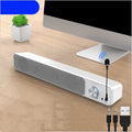 Compact black desktop computer speaker with USB cable on wooden desk