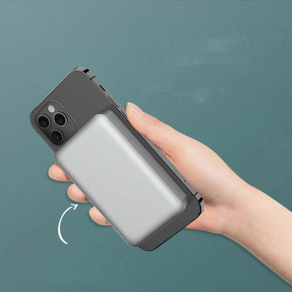 Silver aluminium magnetic wireless charging power bank with USB-C port, shown next to a mobile phone.