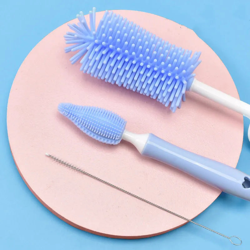 Three-piece baby bottle cleaning brush set with silicone bristles and a straw cleaner in assorted colours.