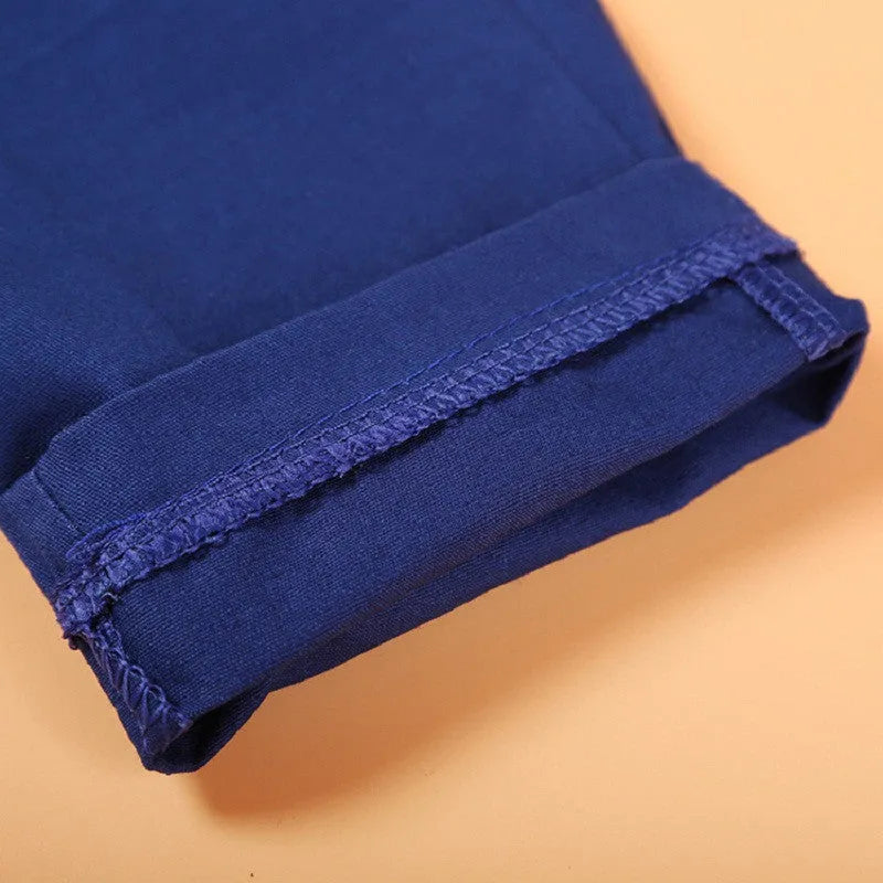 Blue boys' clothing set with turtleneck, waistcoat, tie, and trousers on a hanger.