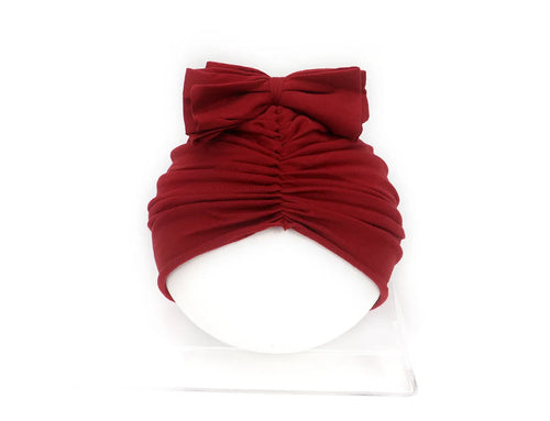 Soft knitted acrylic baby turban hat in a solid colour, shown on a mannequin.