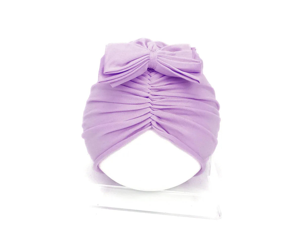 Soft knitted acrylic baby turban hat in a solid colour, shown on a mannequin.