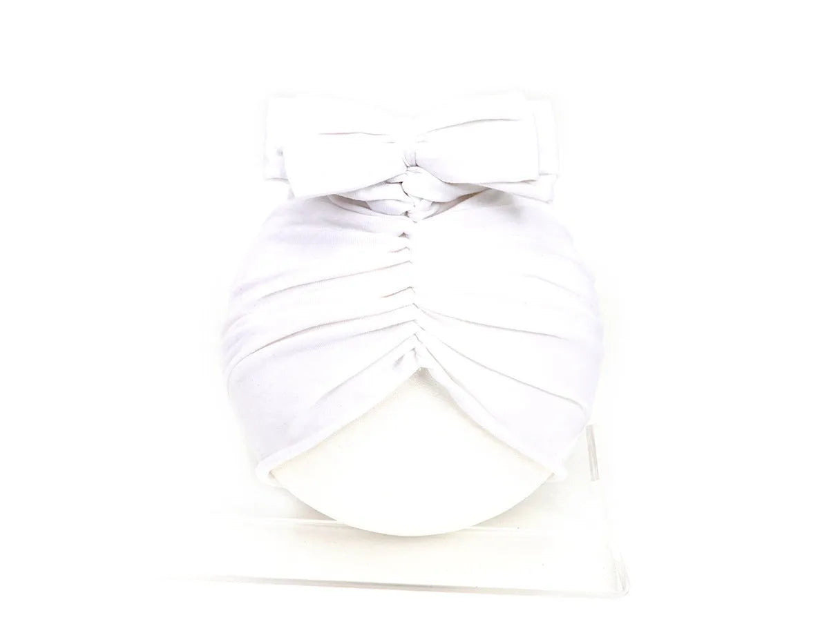 Soft knitted acrylic baby turban hat in a solid colour, shown on a mannequin.