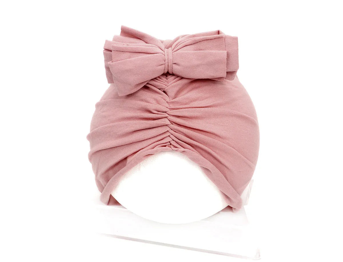 Soft knitted acrylic baby turban hat in a solid colour, shown on a mannequin.