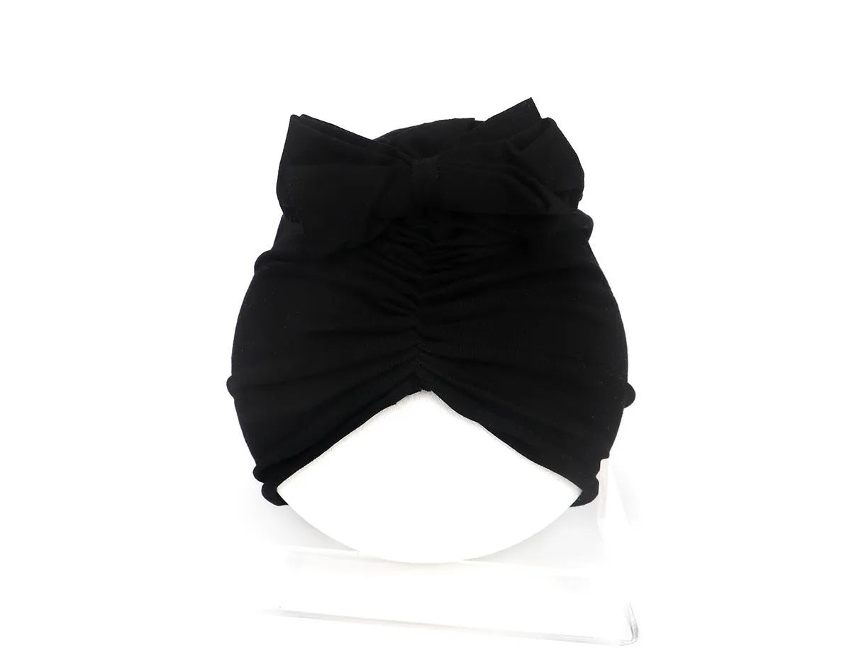 Soft knitted acrylic baby turban hat in a solid colour, shown on a mannequin.