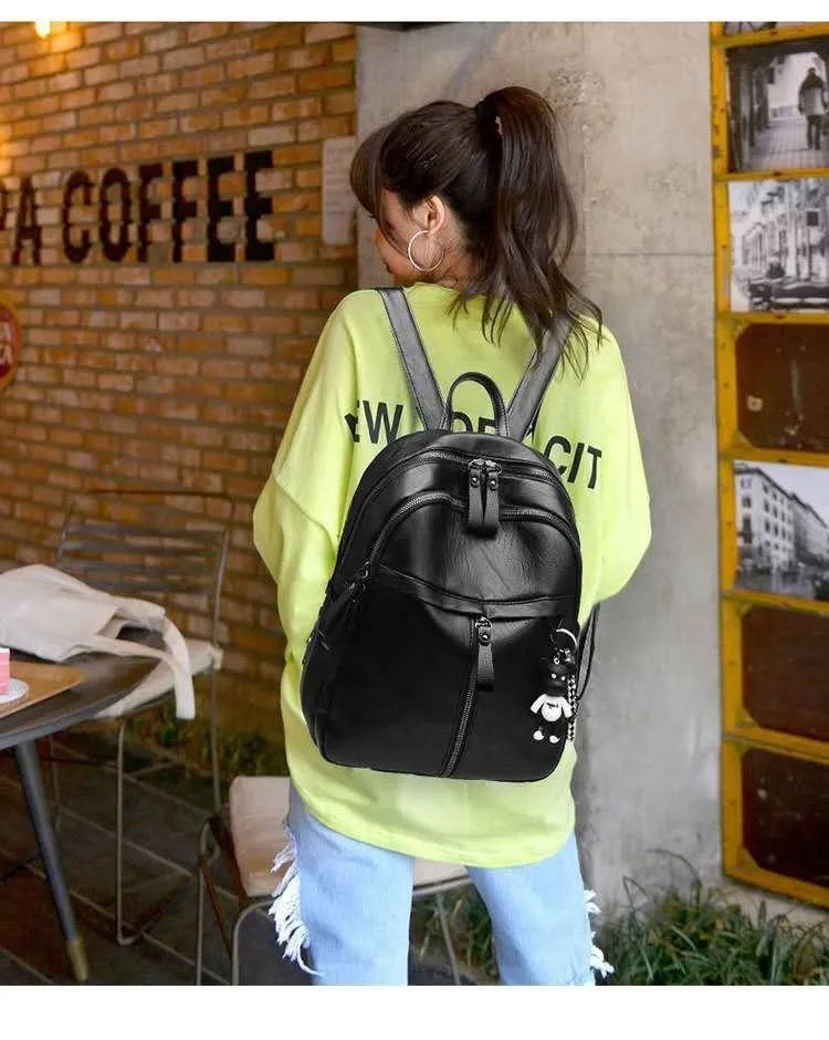 Black PU leather backpack with 20-35L capacity showing zipper opening and double straps