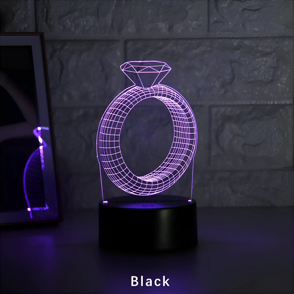 3D diamond ring LED night light with colour-changing illumination on a black base.