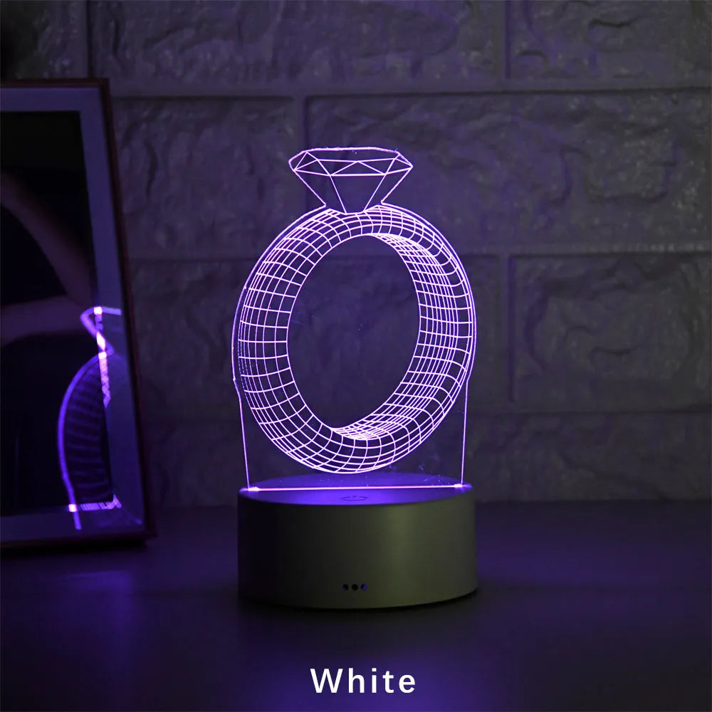 3D diamond ring LED night light with colour-changing illumination on a black base.