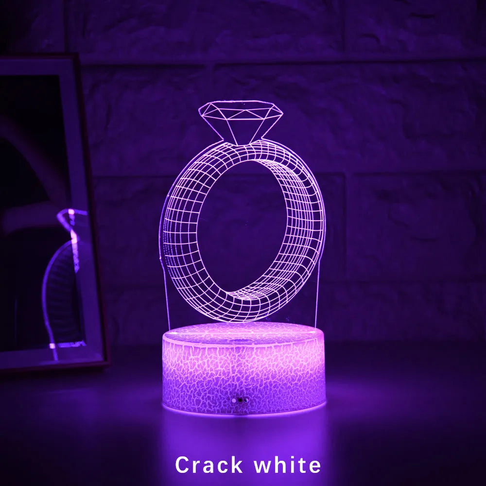 3D diamond ring LED night light with colour-changing illumination on a black base.