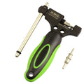 A green steel bicycle chain next to a double shaft chain cutting tool on a workshop surface.