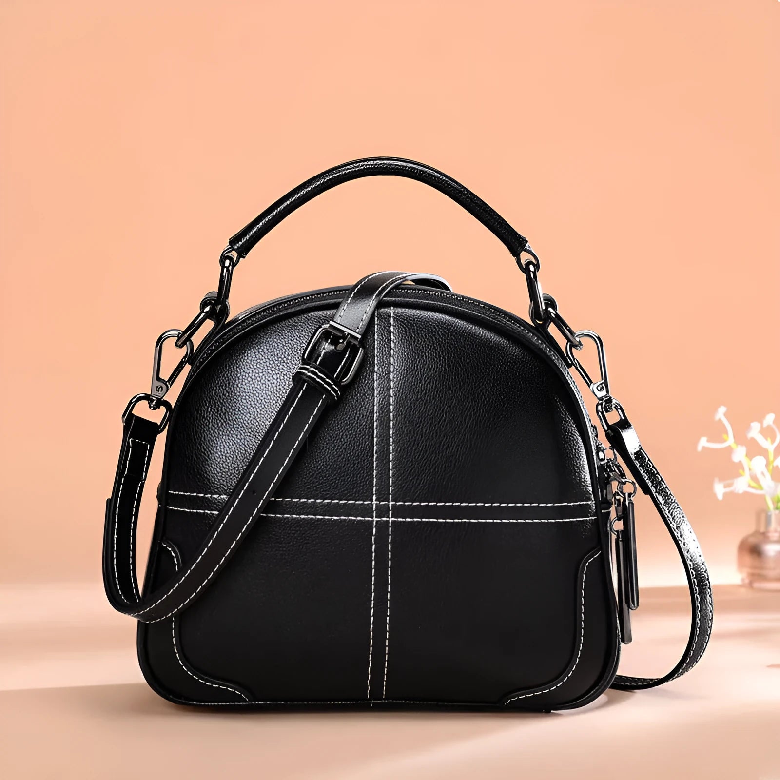 Round leather handbag in wine red with zipper and soft handles showing 21cm dimensions