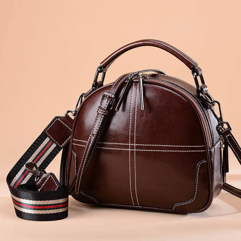 Round leather handbag in wine red with zipper and soft handles showing 21cm dimensions