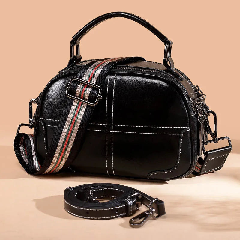 Round leather handbag in wine red with zipper and soft handles showing 21cm dimensions