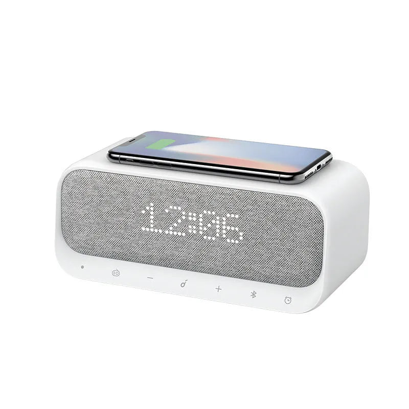 Soundcore white Bluetooth speaker with wireless charging pad and digital display showing alarm clock