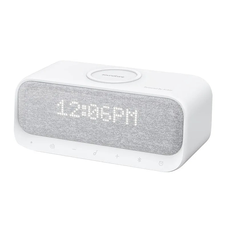 Soundcore white Bluetooth speaker with wireless charging pad and digital display showing alarm clock