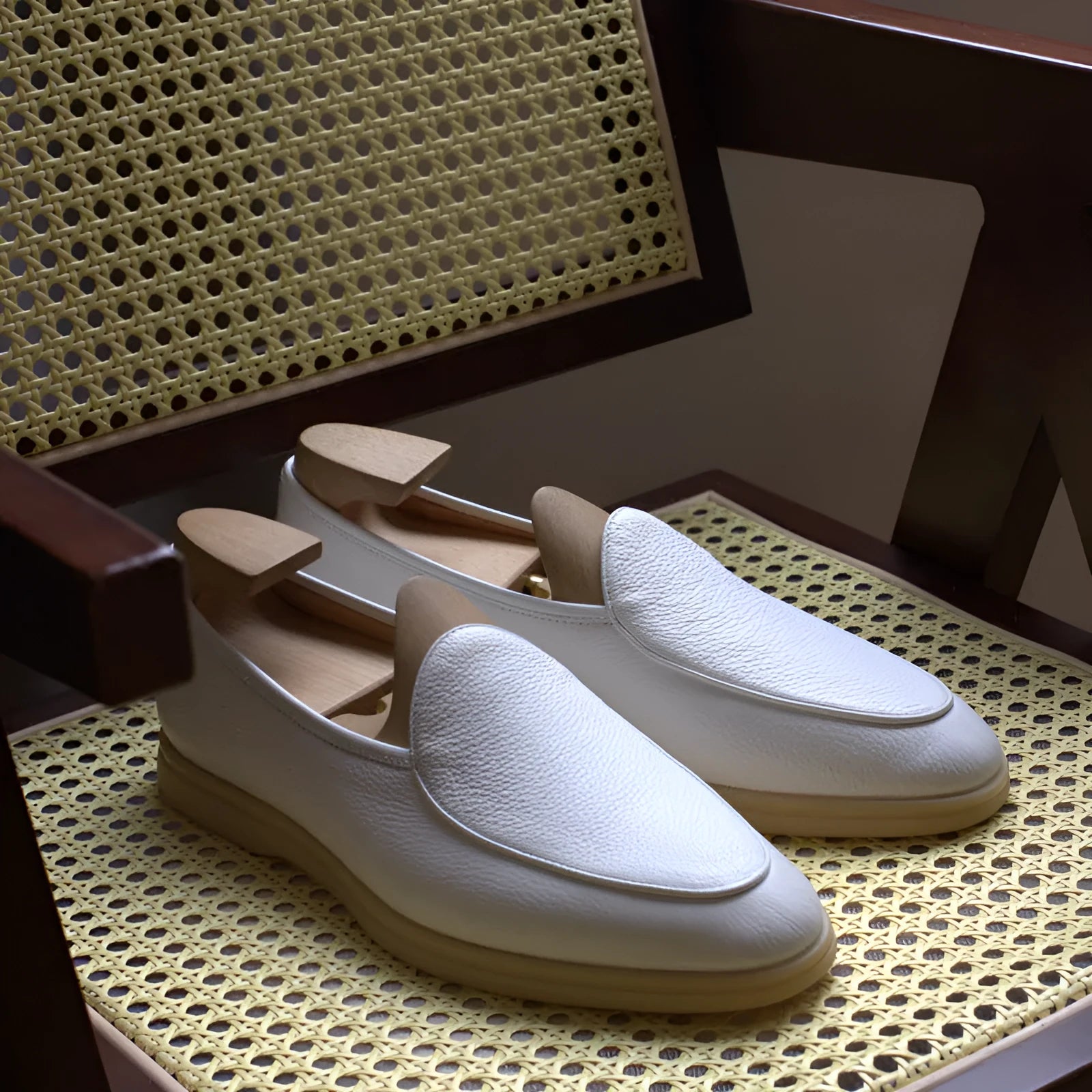 Men's brown genuine leather flat loafers with a low cut and TPR sole on a light background.