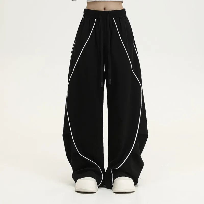Black wide-leg trousers with vertical stripes and a pleated mid-waistband.