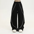Black wide-leg trousers with vertical stripes and a pleated mid-waistband.