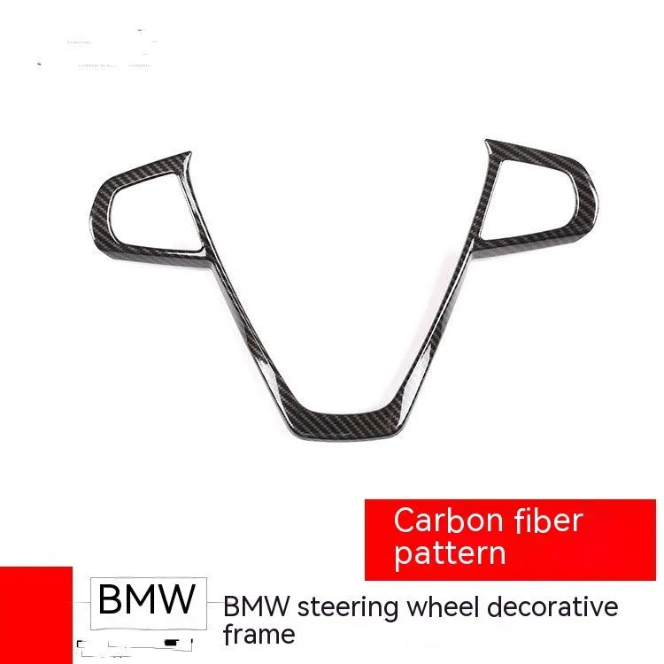 BMW steering wheel button frame decoration in black carbon fibre pattern.
