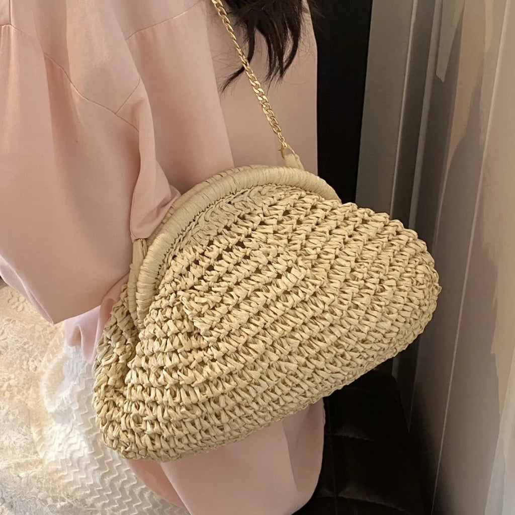 Beige shell-shaped straw shoulder bag with chain strap and woven texture.