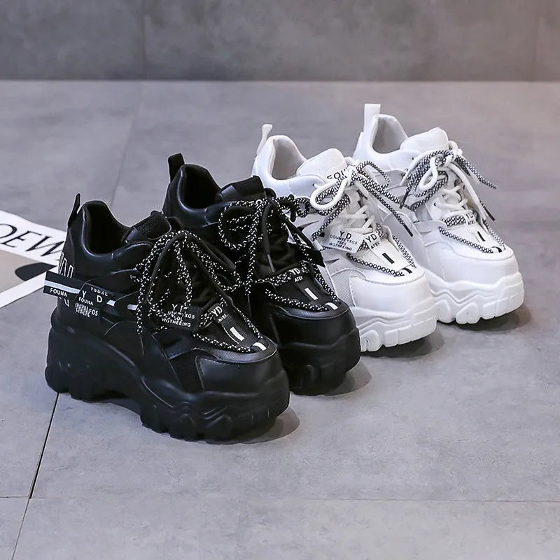 White and black women's mesh platform sports shoes with cross-strap and rubber sole.