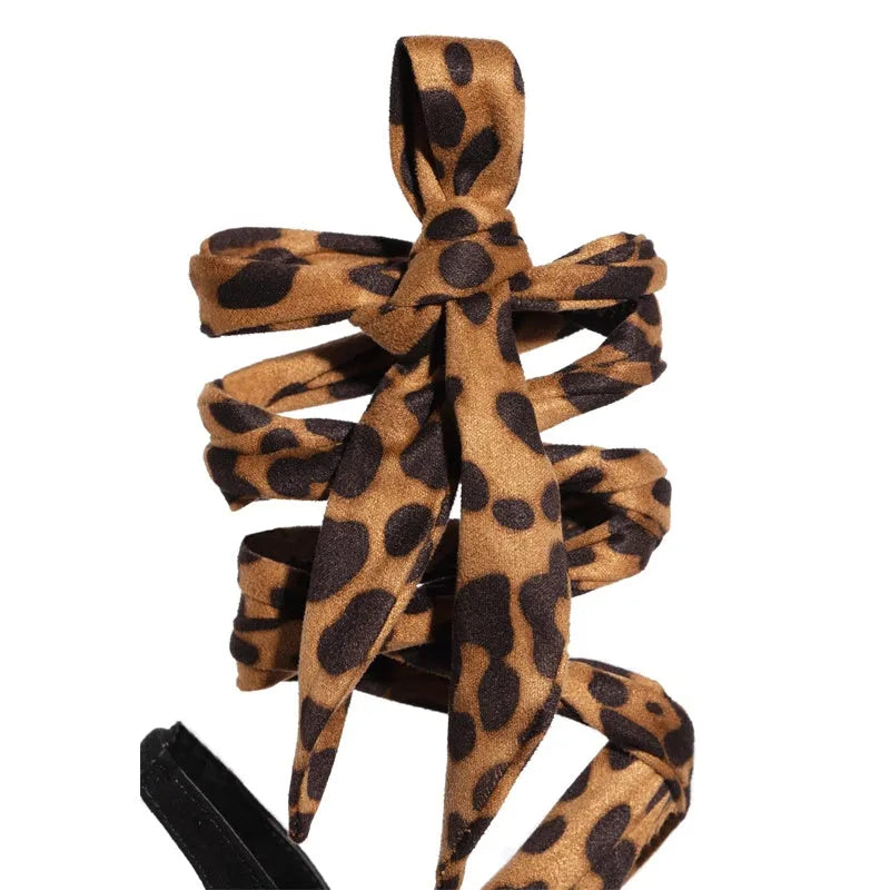 Light brown leopard print women's high heel sandals with cross straps and a thin high heel