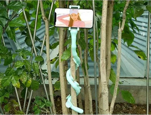 Flexible worm design mobile phone holder with suction cup mounted on desktop showing 360-degree rotation