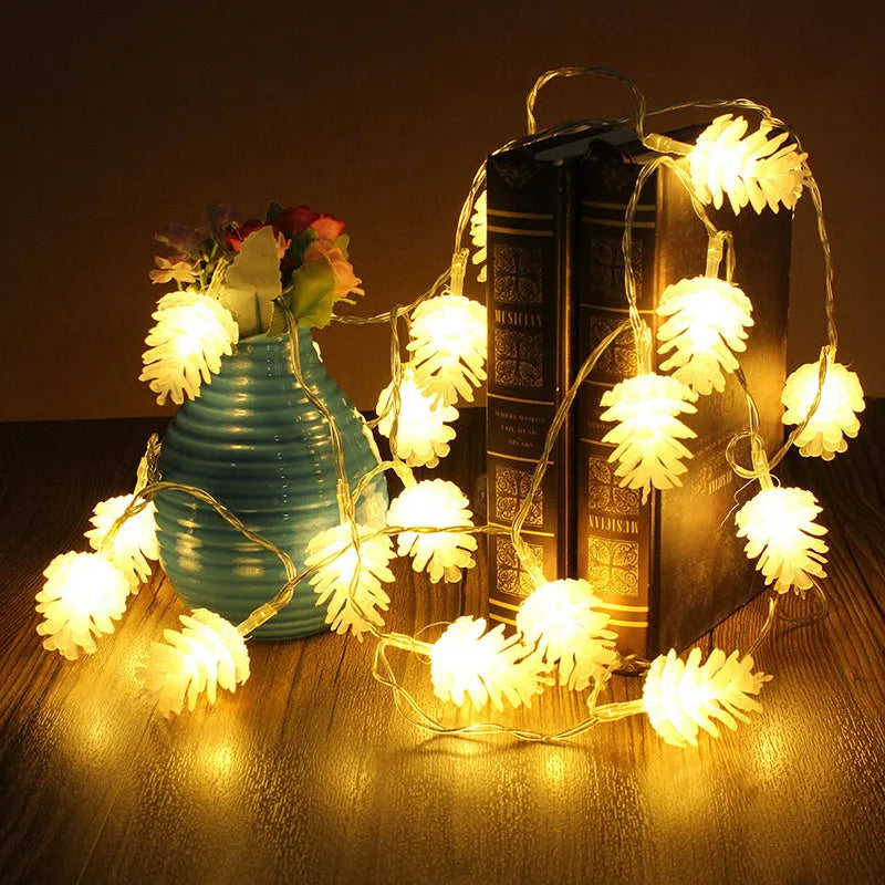 Warm white LED pine cone light string with plastic shells, powered by two AA batteries.