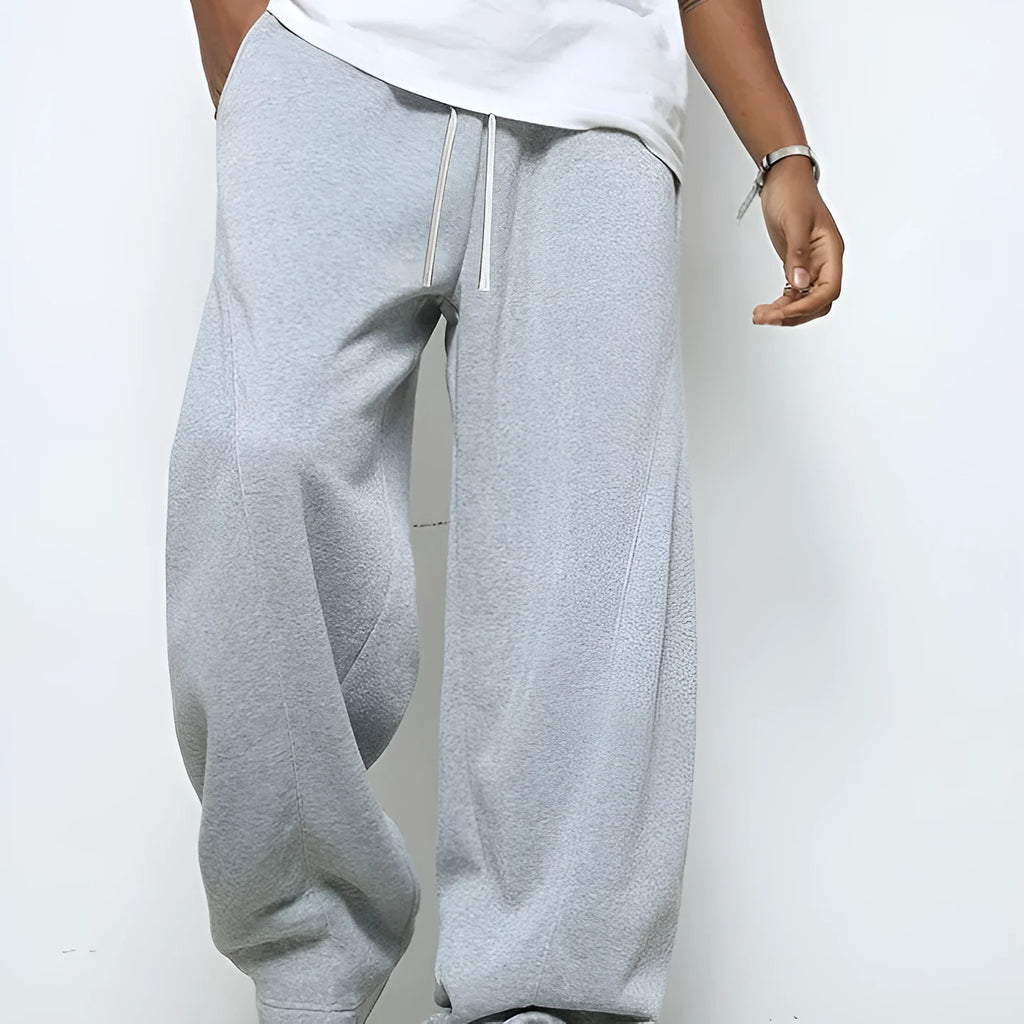 Men's solid colour straight-leg casual trousers with a drawstring waist on a hanger.