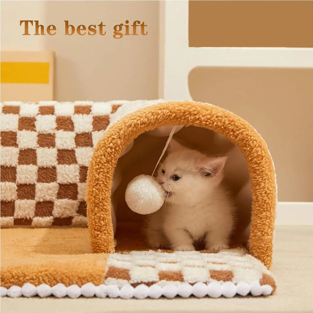 Brown plush plaid cat tunnel bed with central mat on a wooden floor.
