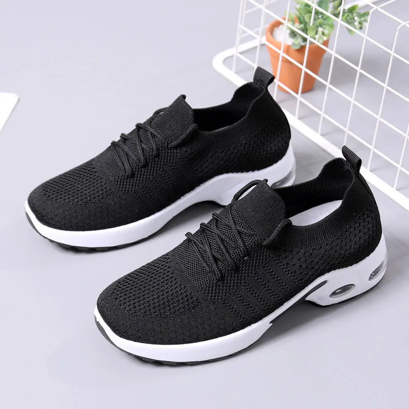 Women's black mesh casual sneakers with round toe and white non-slip sole on a grey background.