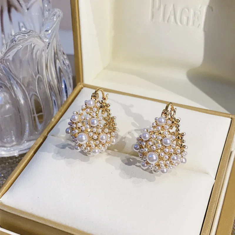 Gold copper flower basket earrings with small rice-shaped bead decoration and pearl inlay.