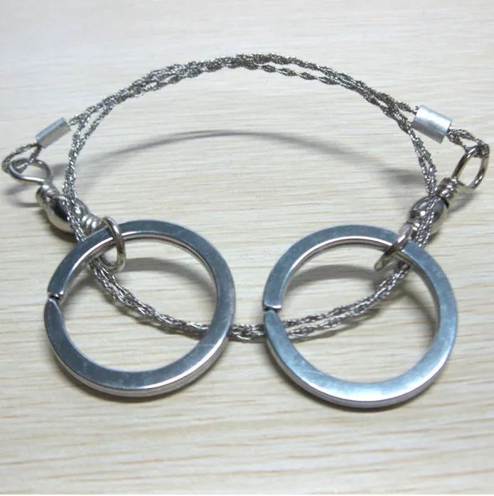 Stainless steel survival wire saw with thumb rings, total length 70cm for outdoor cutting tasks.