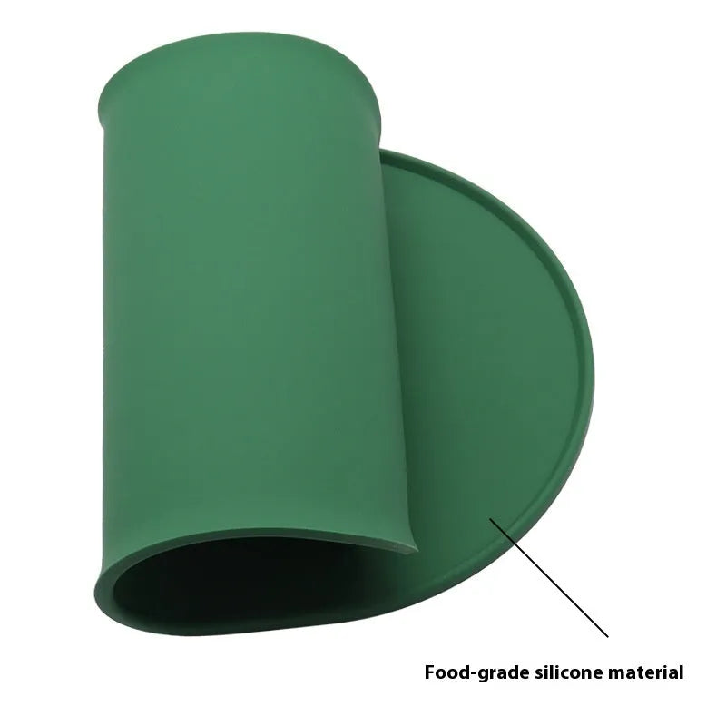 Silicone waterproof cat feeding placemat in beige colour on a wooden floor next to a pet bowl.