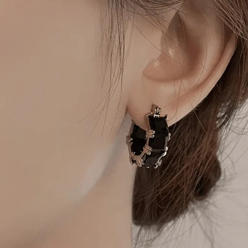 Geometric U-shaped gold earrings with round accents and black zircon stones