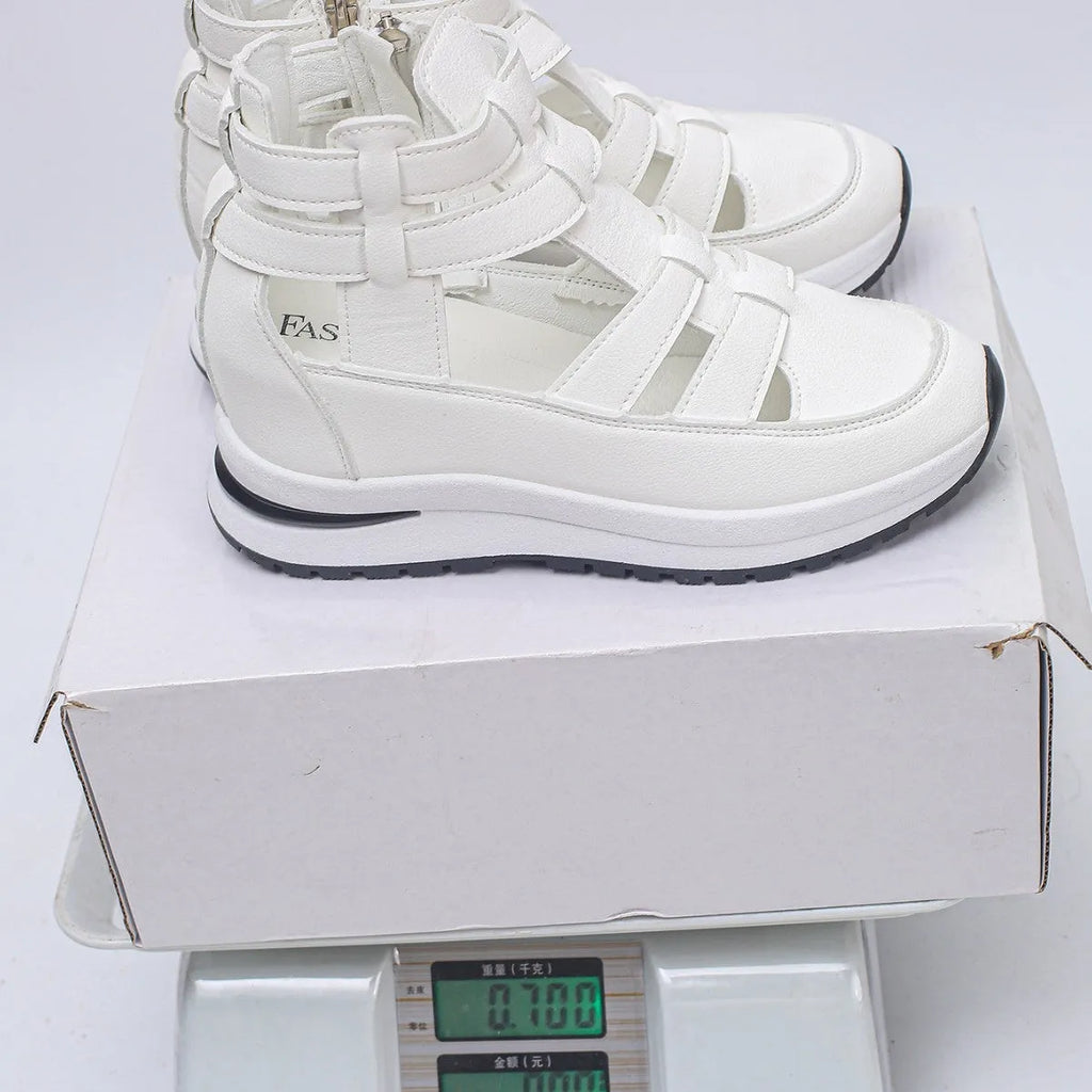 Women's black close-toed hollow-out platform sandals with a Velcro strap on a white background.